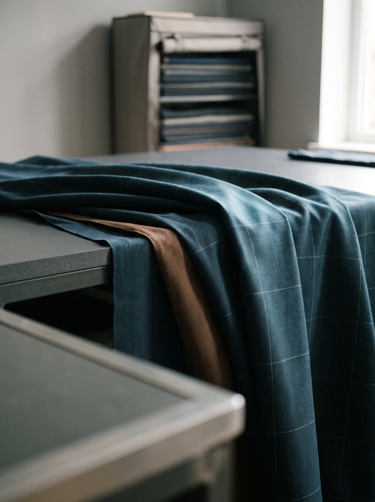 Petrol blue and tobacco wool cloth on a cutting table