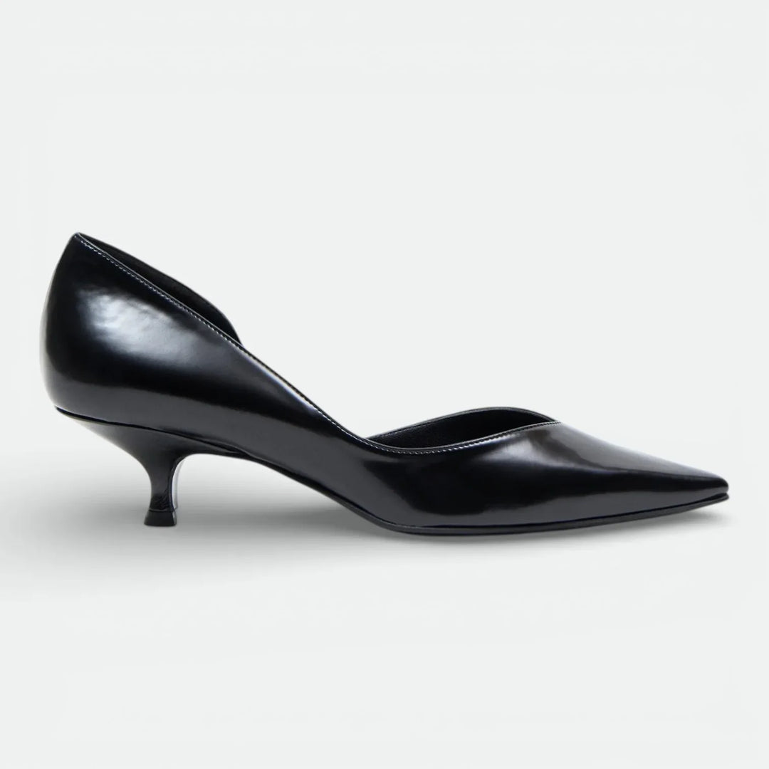 Black pointed-toe kitten heel pump with glossy leather finish on white background