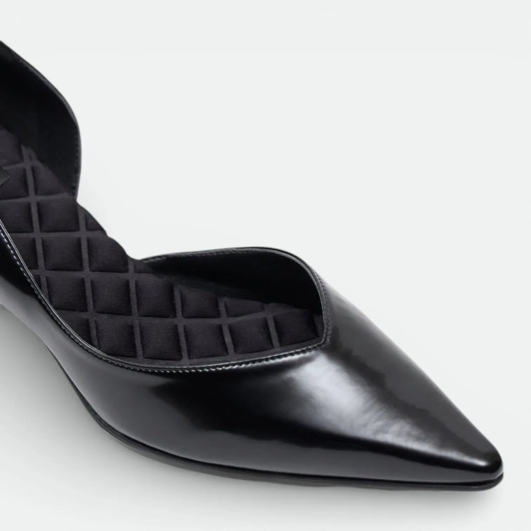 Black pointed-toe flat shoe with quilted cushioned insole on white background