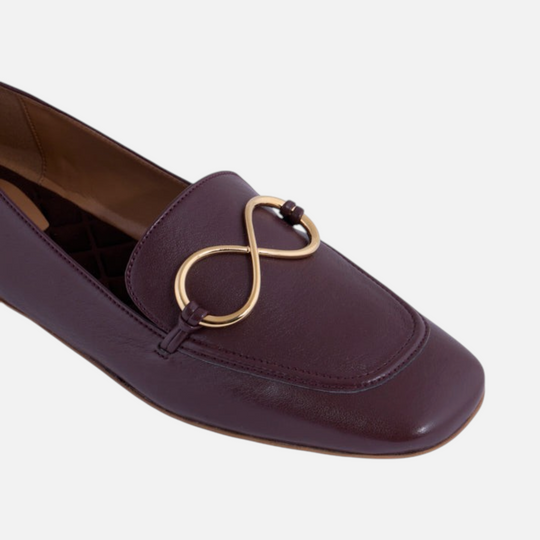 AERA ELLA chestnut nappa-effect loafer, close-up of the gold-tone infinity hardware and rounded toe.