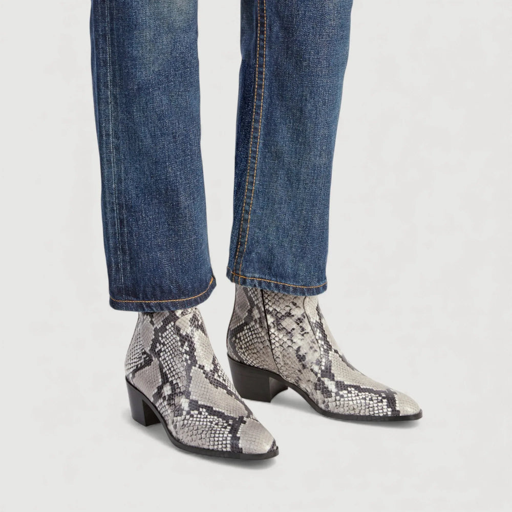 Model wearing AERA NEW YORK LUXURY VEGAN SHOES, STEFFY | Beige Faux-Snake Print - Ankle Boots with silver hardware and 45mm heel.