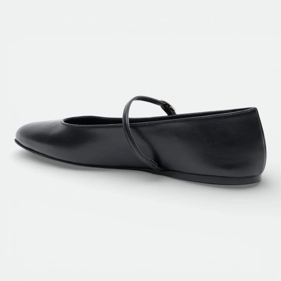 Black leather Mary Jane flat shoe with a slim strap, side view on white background