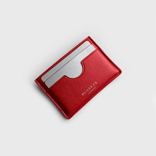 slim red leather card holder with two silver cards on light background