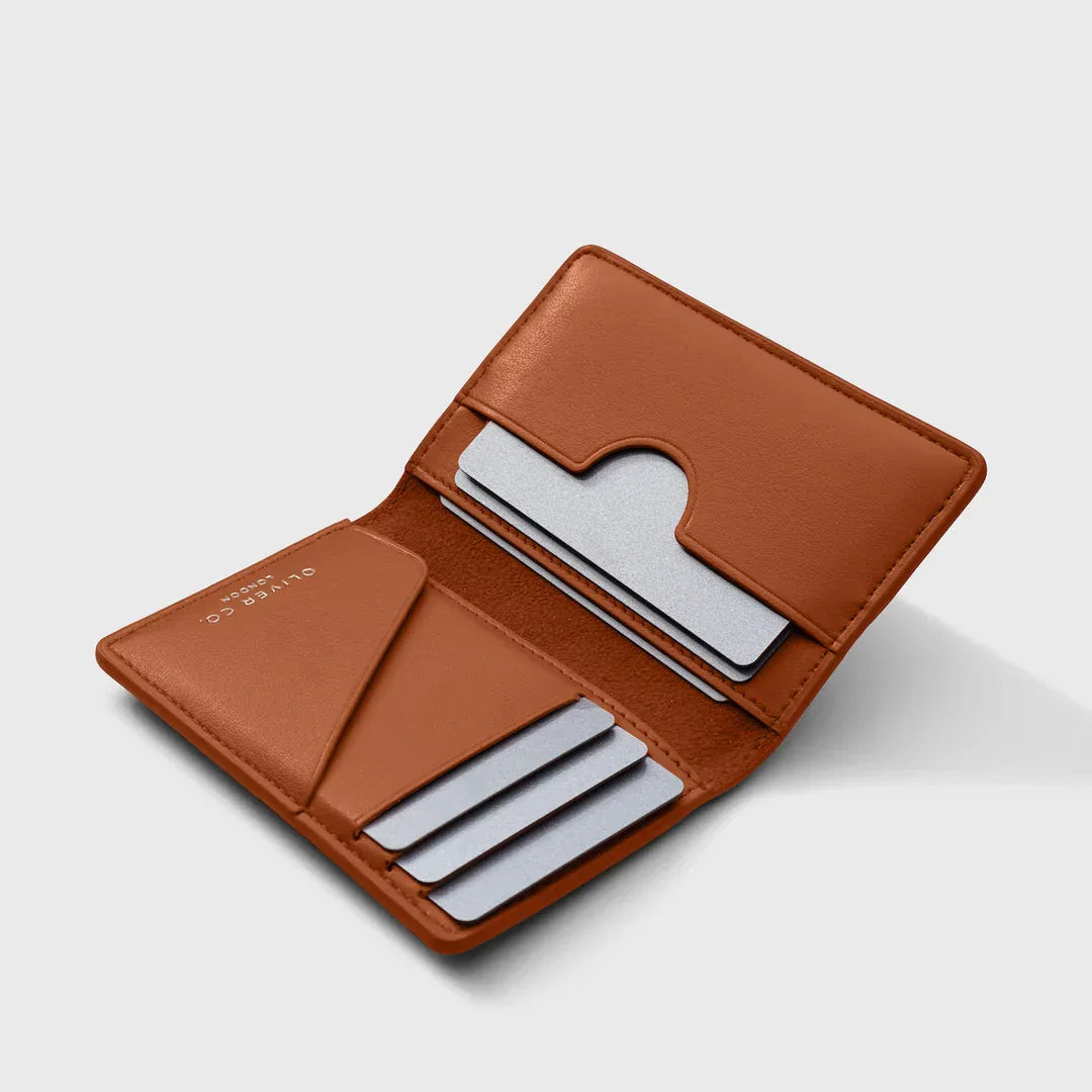 Open burnt orange leather wallet with card slots and minimalist design on white background