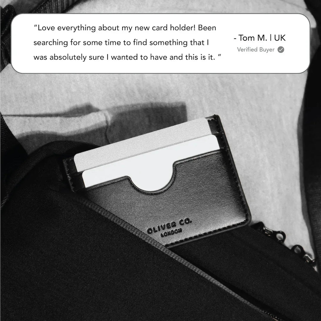 Slim black leather card holder with cards inside pocket, embossed with Oliver Co. London logo.