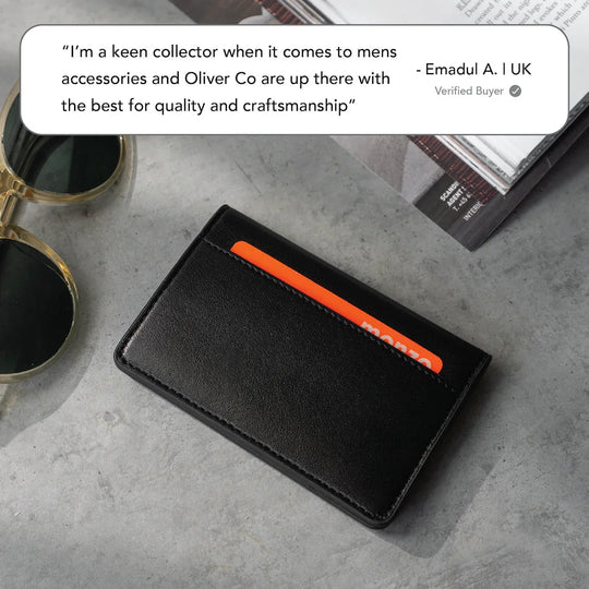 Slim black leather card wallet on concrete with sunglasses and magazine, minimalist men&
