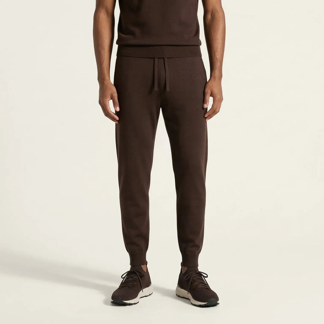 Men's brown knit jogger pants with drawstring waist and ribbed cuffs, paired with sneakers