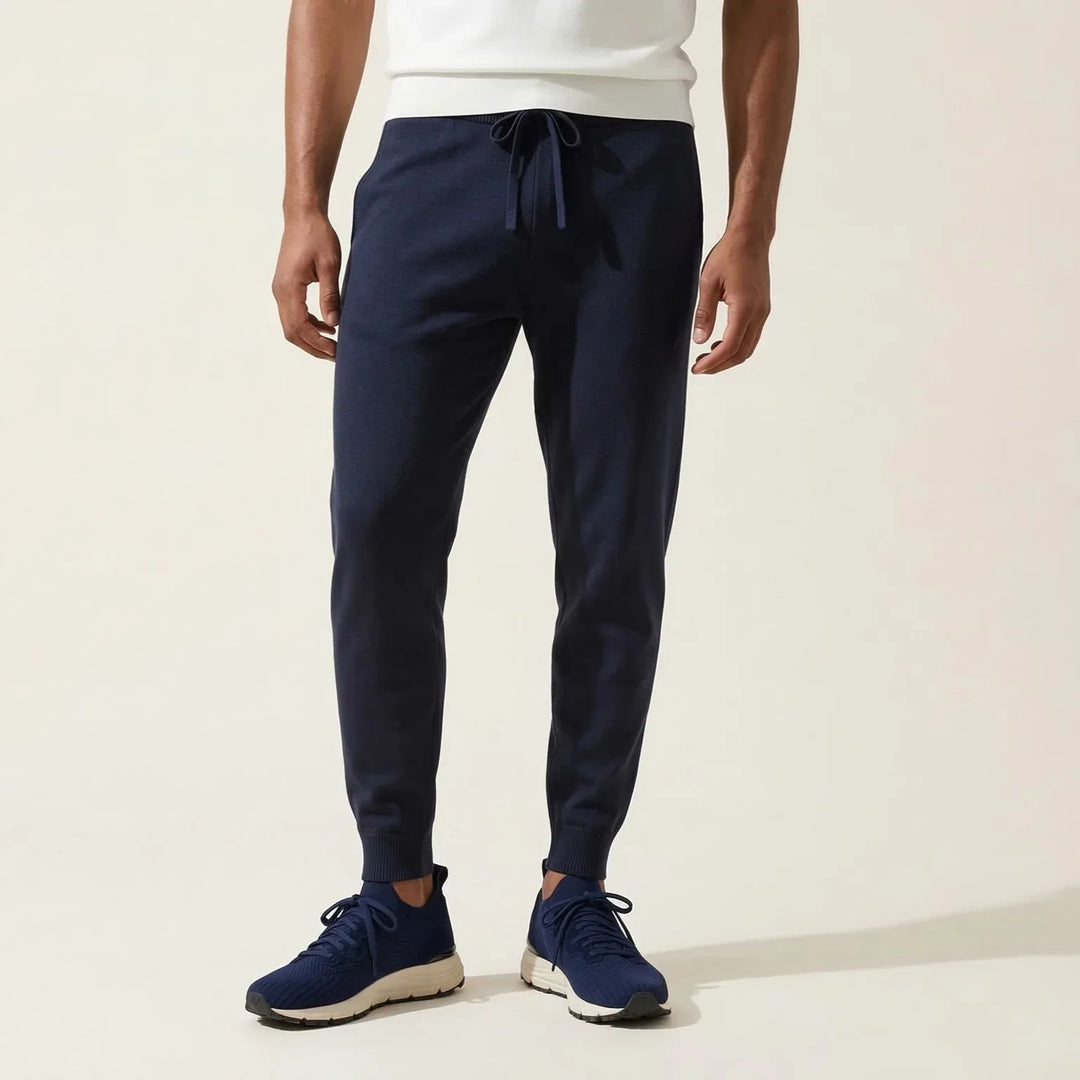Man wearing navy blue drawstring jogger pants and matching sneakers