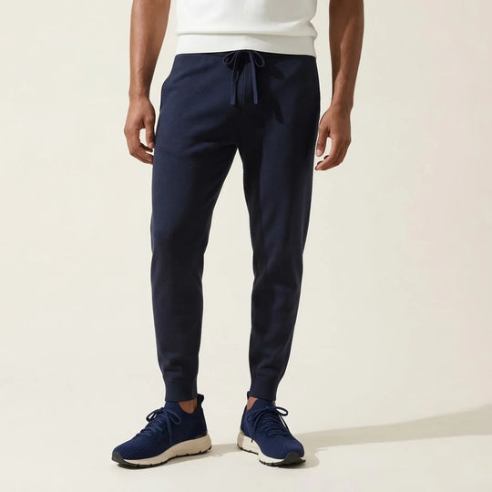 Man wearing navy blue drawstring jogger pants and matching sneakers