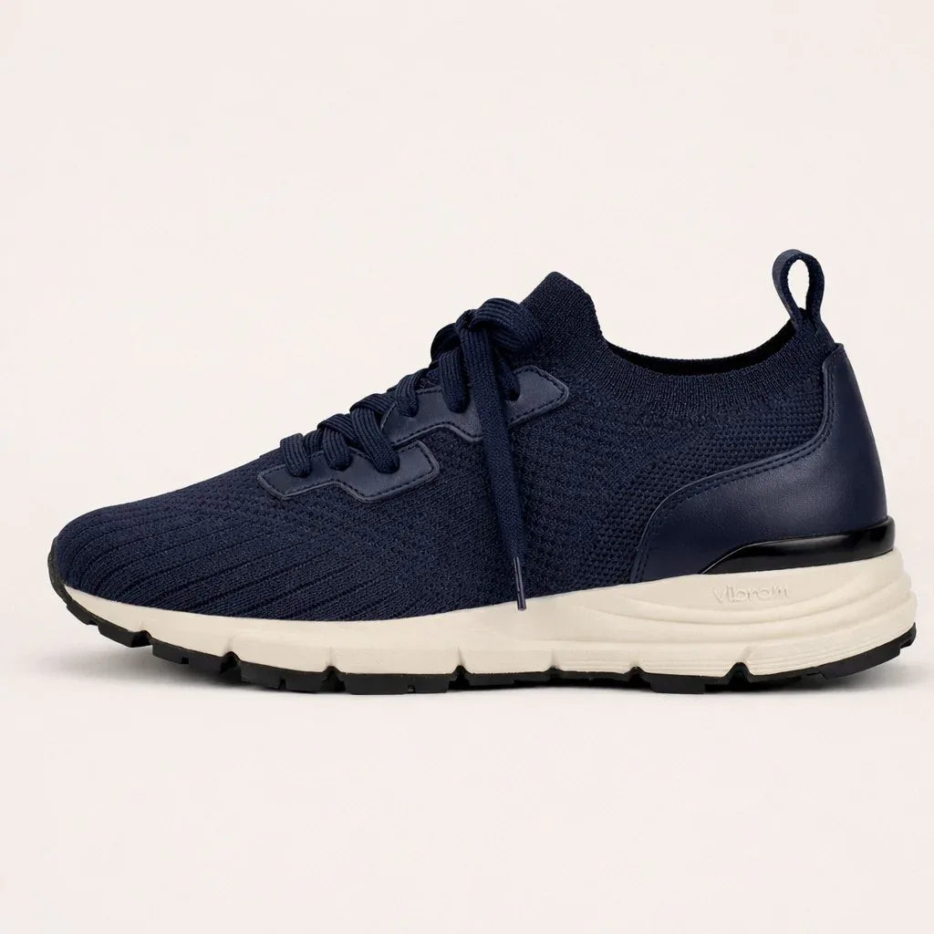 Navy blue suede knit sneaker with white Vibram sole and black outsole, side view