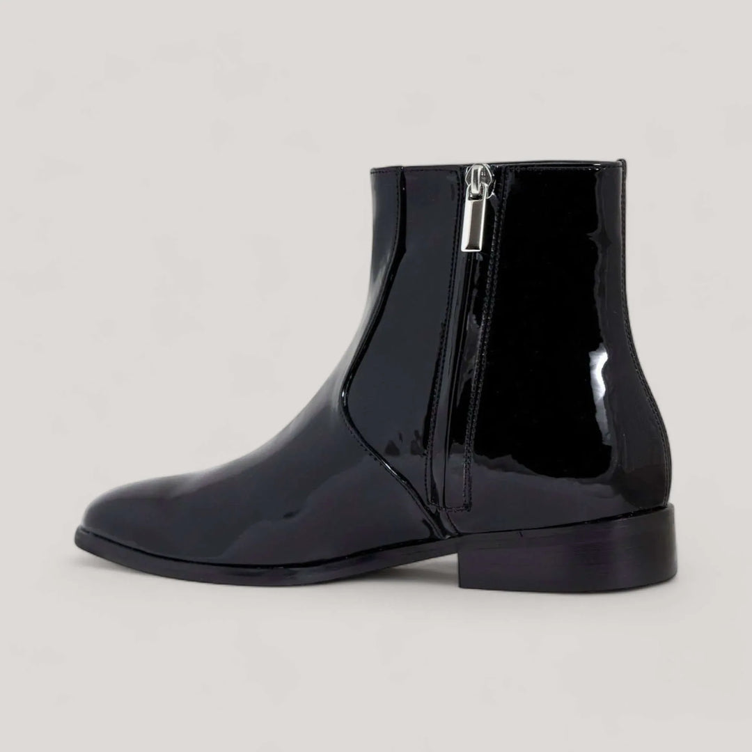 Black vegan patent leather ankle boot by AERA, sustainable and carbon-neutral design. Handcrafted in Italy, inspired by Stella McCartney.