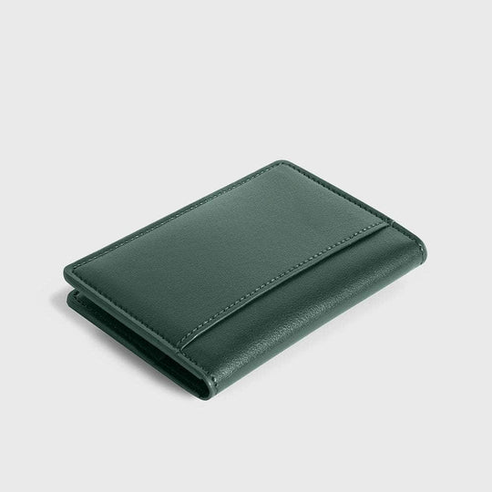 Slim green vegan leather compact wallet on a light background