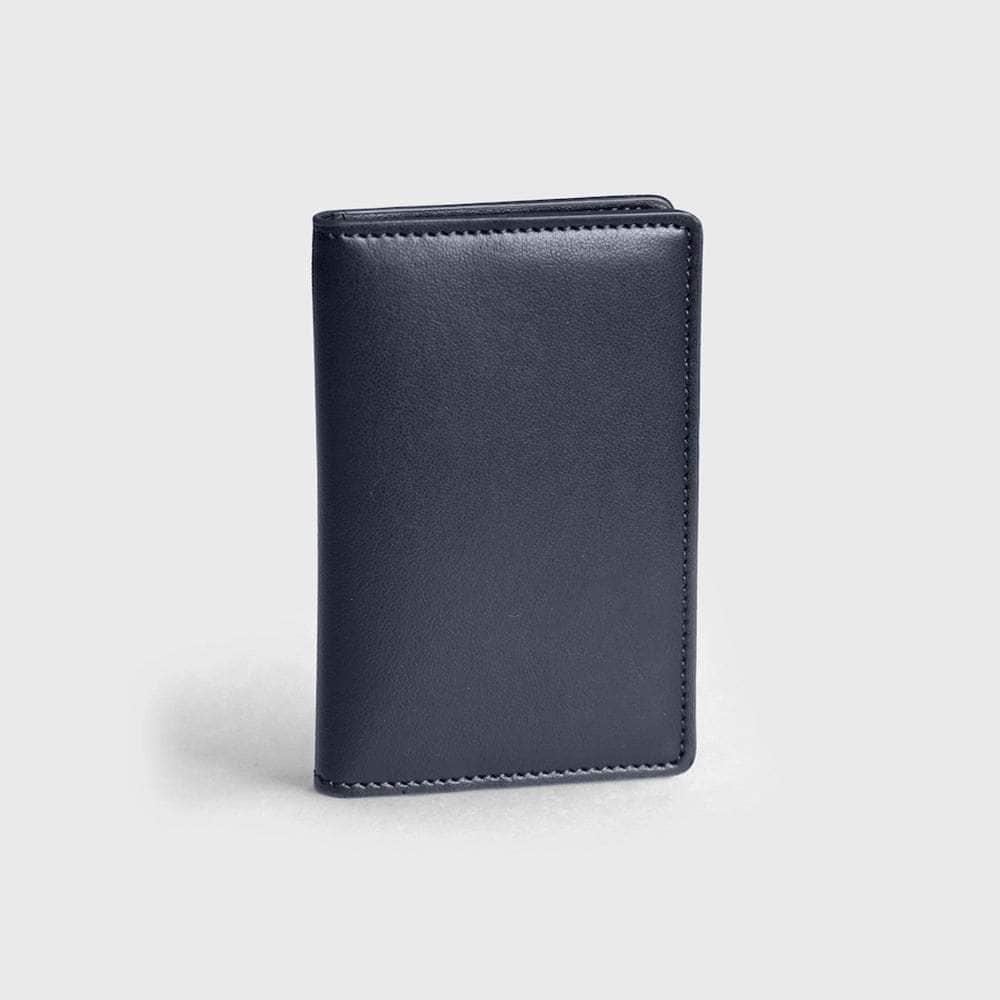 Slim black vegan leather compact wallet standing on light gray background