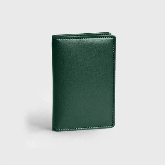 Green vegan leather compact wallet with smooth finish on a plain white background