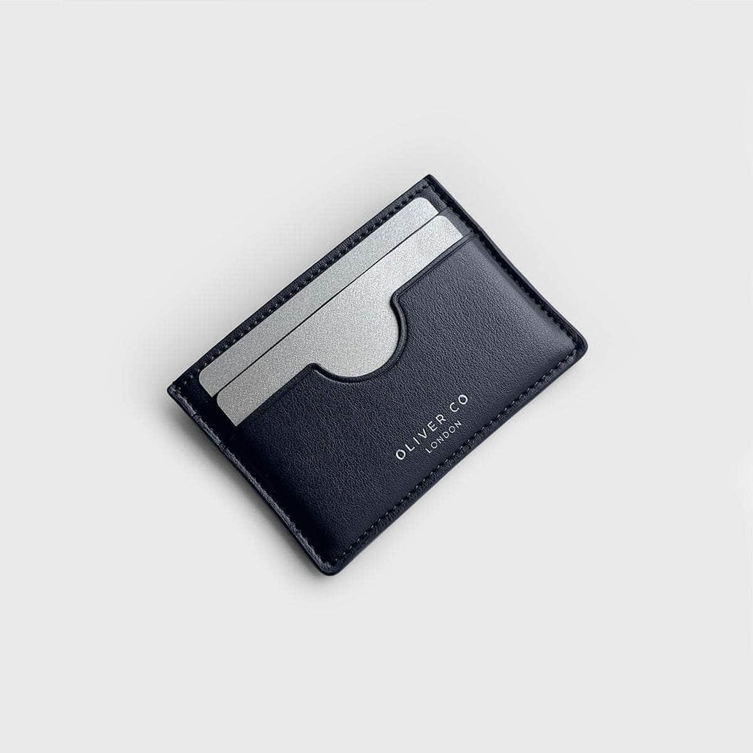 Slim black vegan card holder with two silver cards on a light background.
