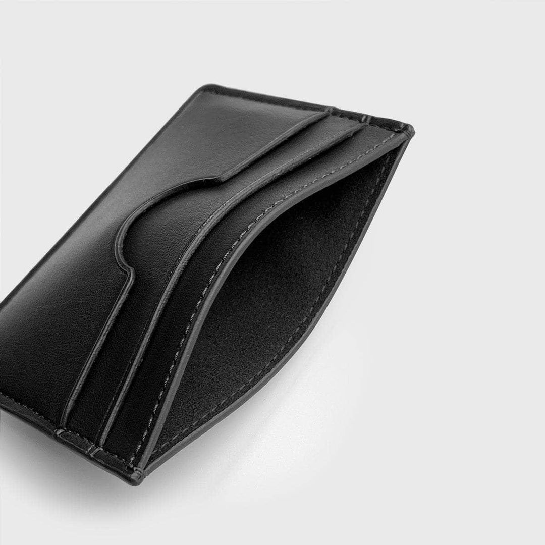 Black slim vegan card holder with multiple slots on a light background