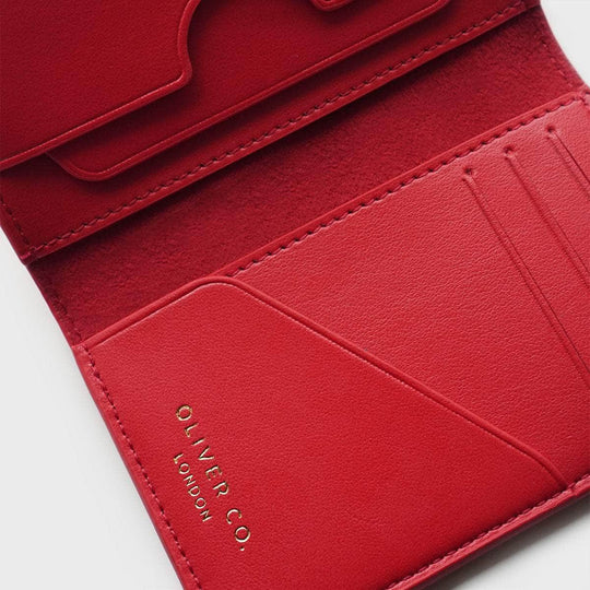 Open red vegan compact wallet with card slots and gold embossed logo