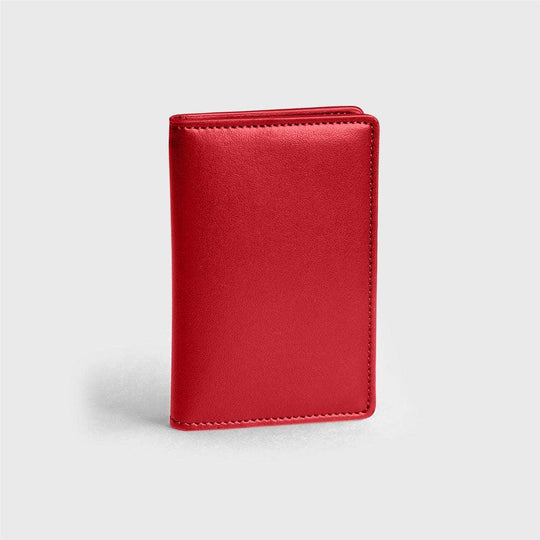 Red vegan leather compact wallet standing on a light gray background